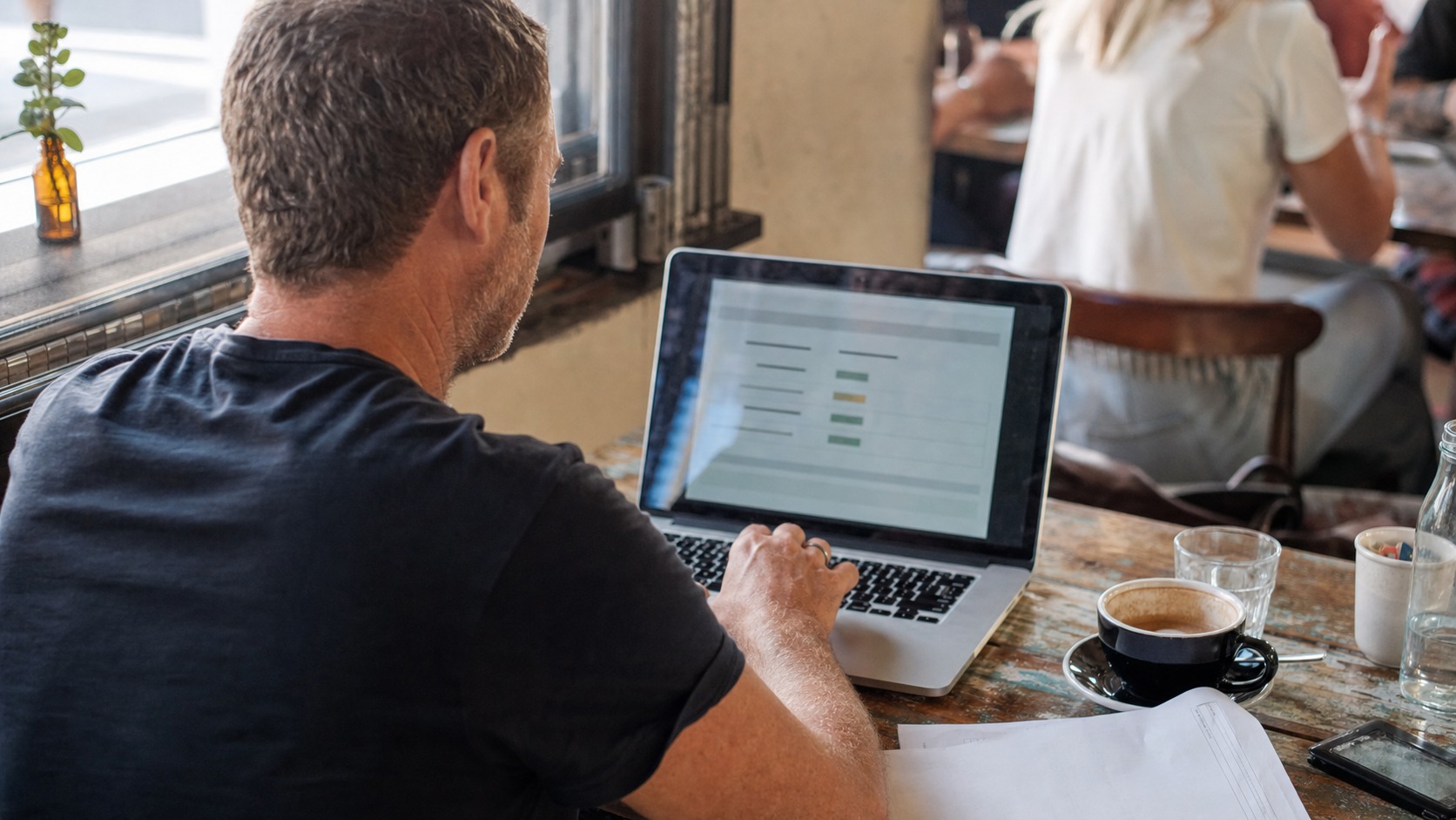 Australian small business owner checking the new .au domain rules on a laptop at a cafe