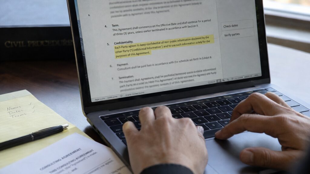 Reviewing an AI-drafted contract clause on a laptop in a law firm